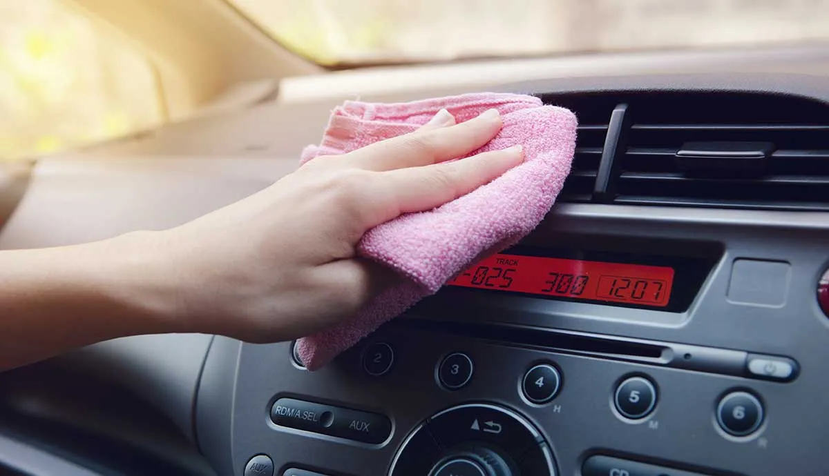 person dusting interior of car