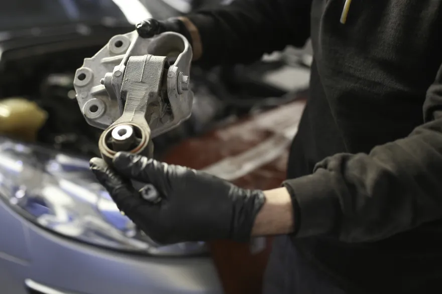 mechanic holding motor mount